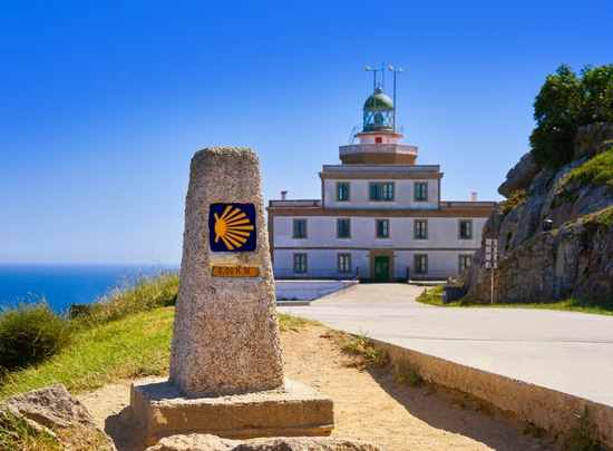 Cape Fisterra lighthouse and Camino de Santiago waymarker stone, Galicia