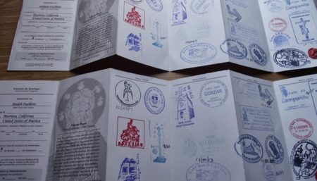 Inside pages of a Camino Pilgrim Passport showing collected stamps along the Camino de Santiago.